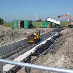 De asfalt laag wordt aan gebracht